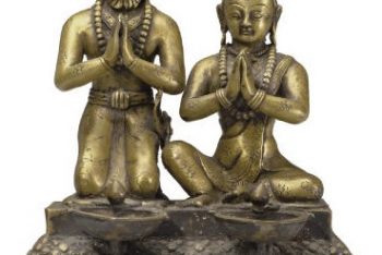 A brass ritual lamp with figures of a King and Queen