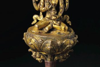 A gilt bronze figure of a deity with attendants